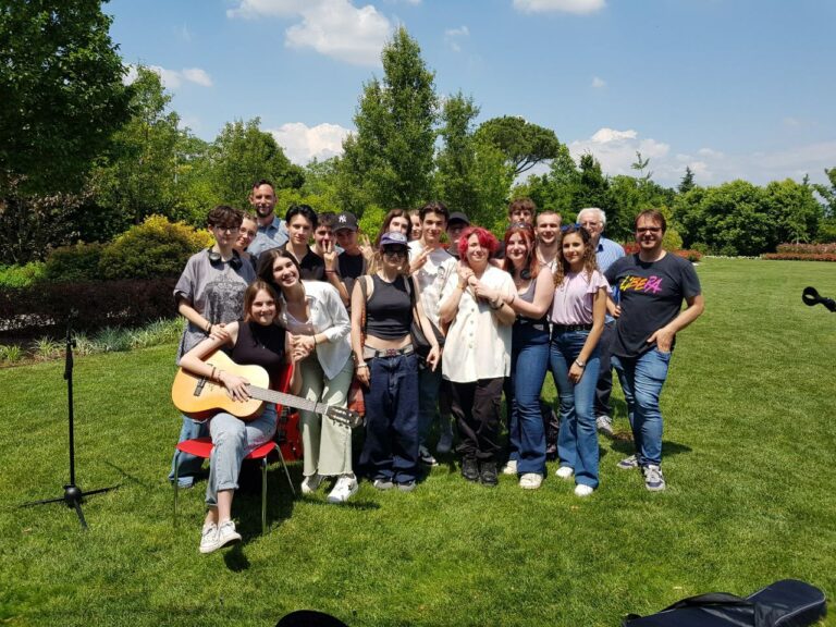 Un gruppo di ragazzi della scuola superiore che si abbraccia su un prato verde